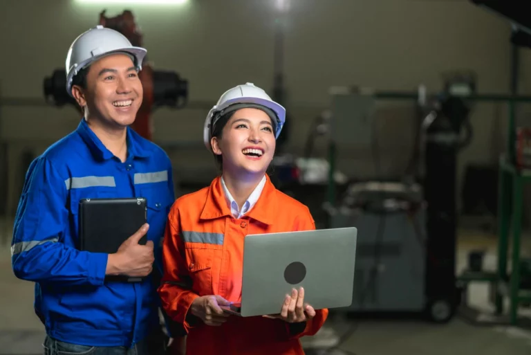 portrait-asian-emgineer-male-female-technician-safty-uniform-standing-turn-around-look-camera-laugh-smile-with-cheerful-confident-machinery-factory-workplace-background