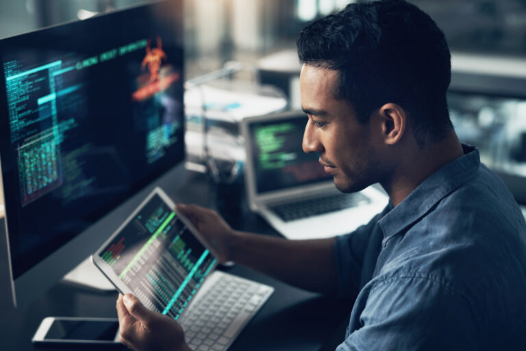 Programming, employee and man with a tablet, cyber security and computer in a modern office. Male person, programmer and coder with technology, coding and digital software with internet connection